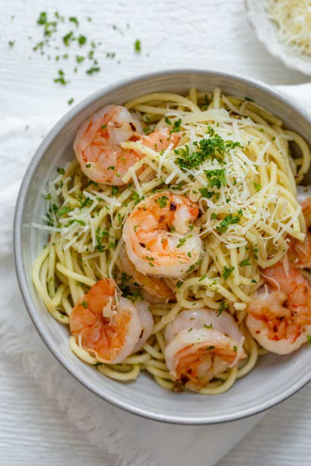 Garlic butter shrimp pasta served in a bowl with parsley and parmesan cheese