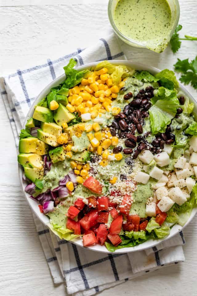 Mexican chopped salad in a large bowl drizzled with the dressing on the side