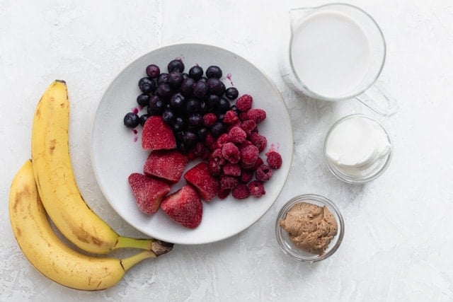 Ingredients to make the recipe: bananas, berries, milk, greek yogurt and almond butter