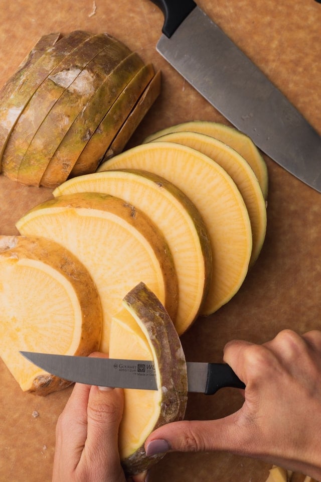 Peeling the skin off rutabaga fries