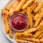 Oven baked rutabaga fries on a plate with ketchup
