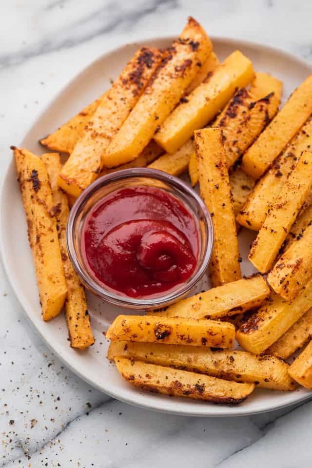 Ofengebackene Steckrüben-Pommes auf einem Teller mit Ketchup