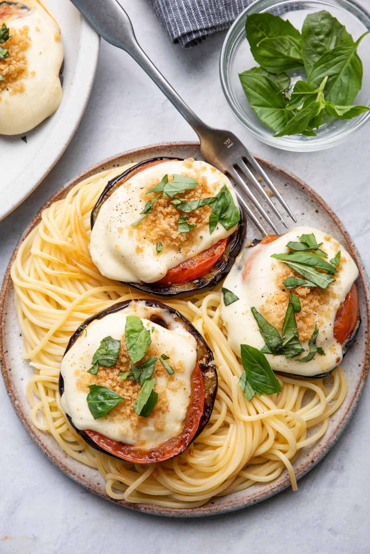 3 slices of eggplant parmesan on top of spaghetti