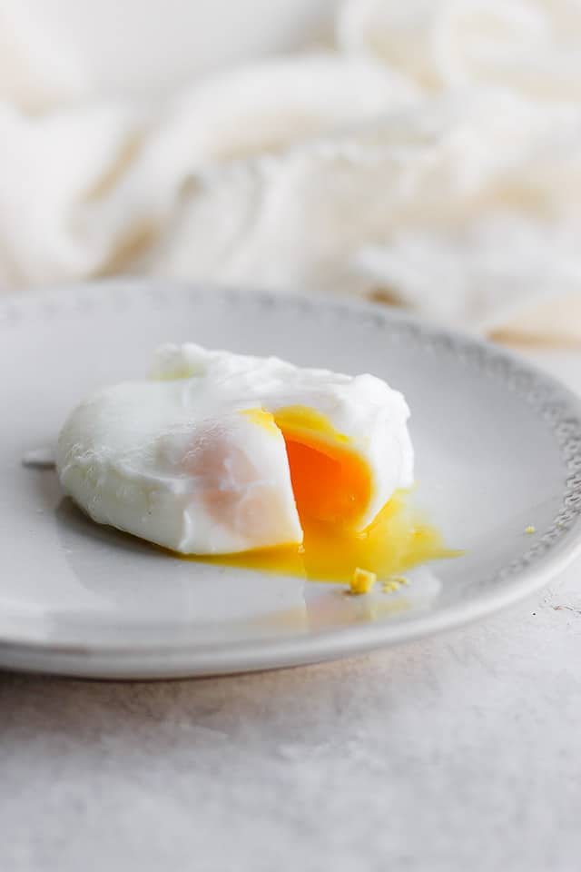 More firm poached egg on a gray plate