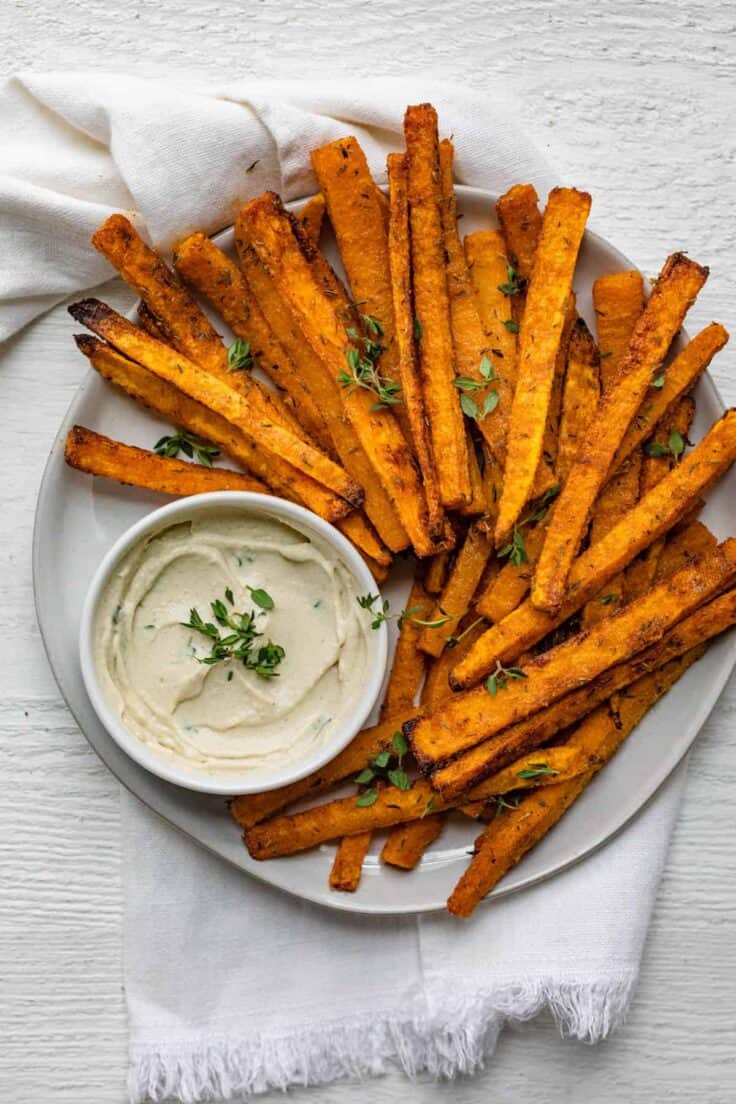 Round plate of fries with mayo dipping sauce for the butternut squash sticks