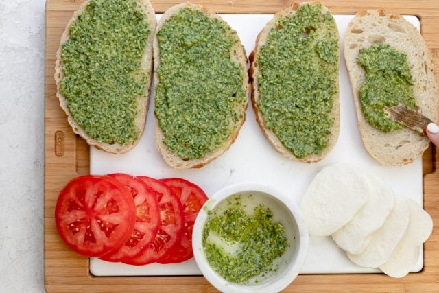 Spreading walnut pesto on the bread before assembling and grilling