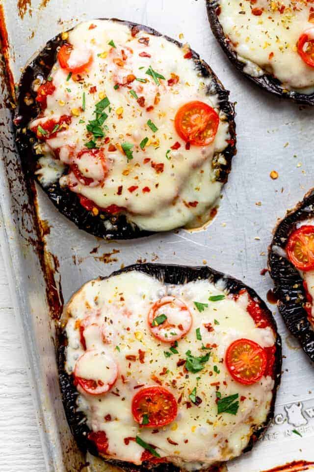 Close up shot of the portobello mushroom pizzas with the toppings after cooking with cheese melting