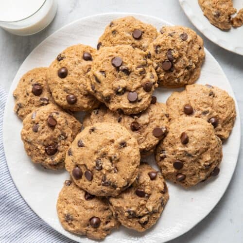 Plate of applesauce chocolate chip cookies with glass of milk next to them