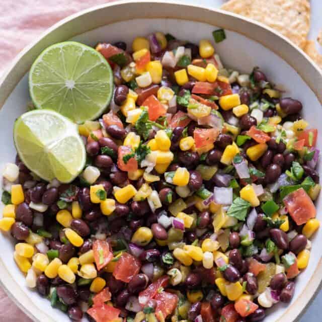 Black bean salsa with limes served with chips on the side