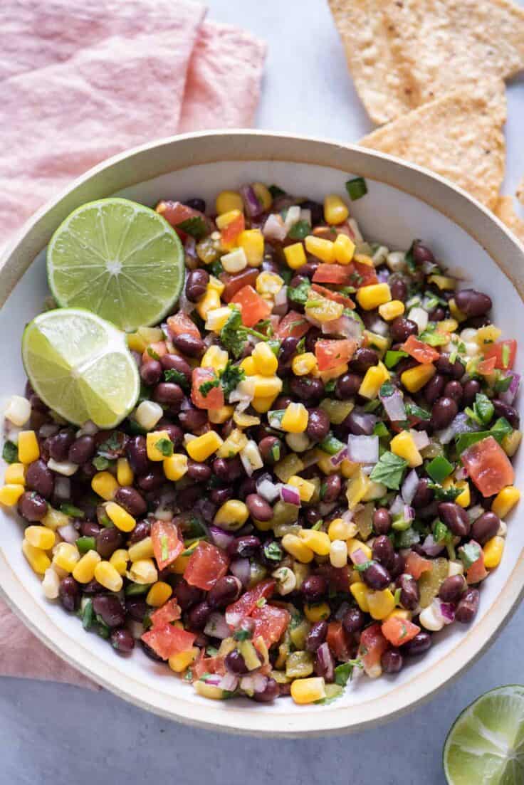 Black bean salsa with limes served with chips on the side