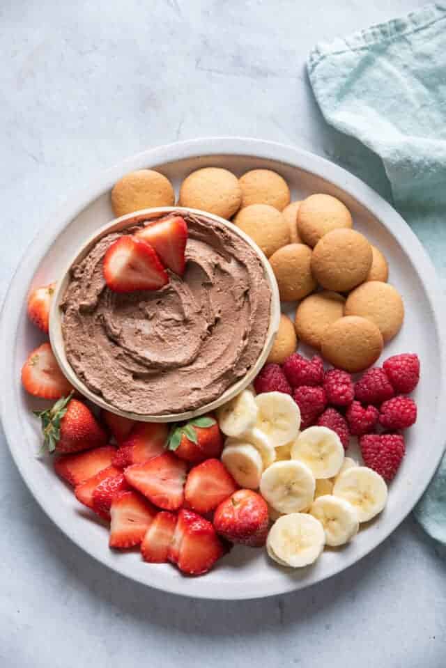 Chocolate Peanut Butter Dip on a plate with fruit and wafers for dippings