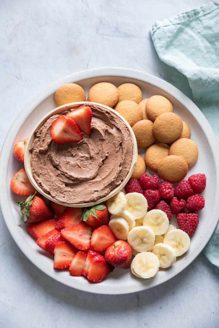 Chocolate Peanut Butter Dip on a plate with fruit and wafers for dippings
