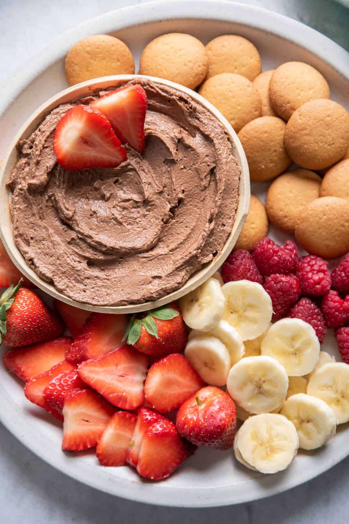 chocolate peanut butter dip with strawberries, bananas, raspberries and vanilla wafers for dipping