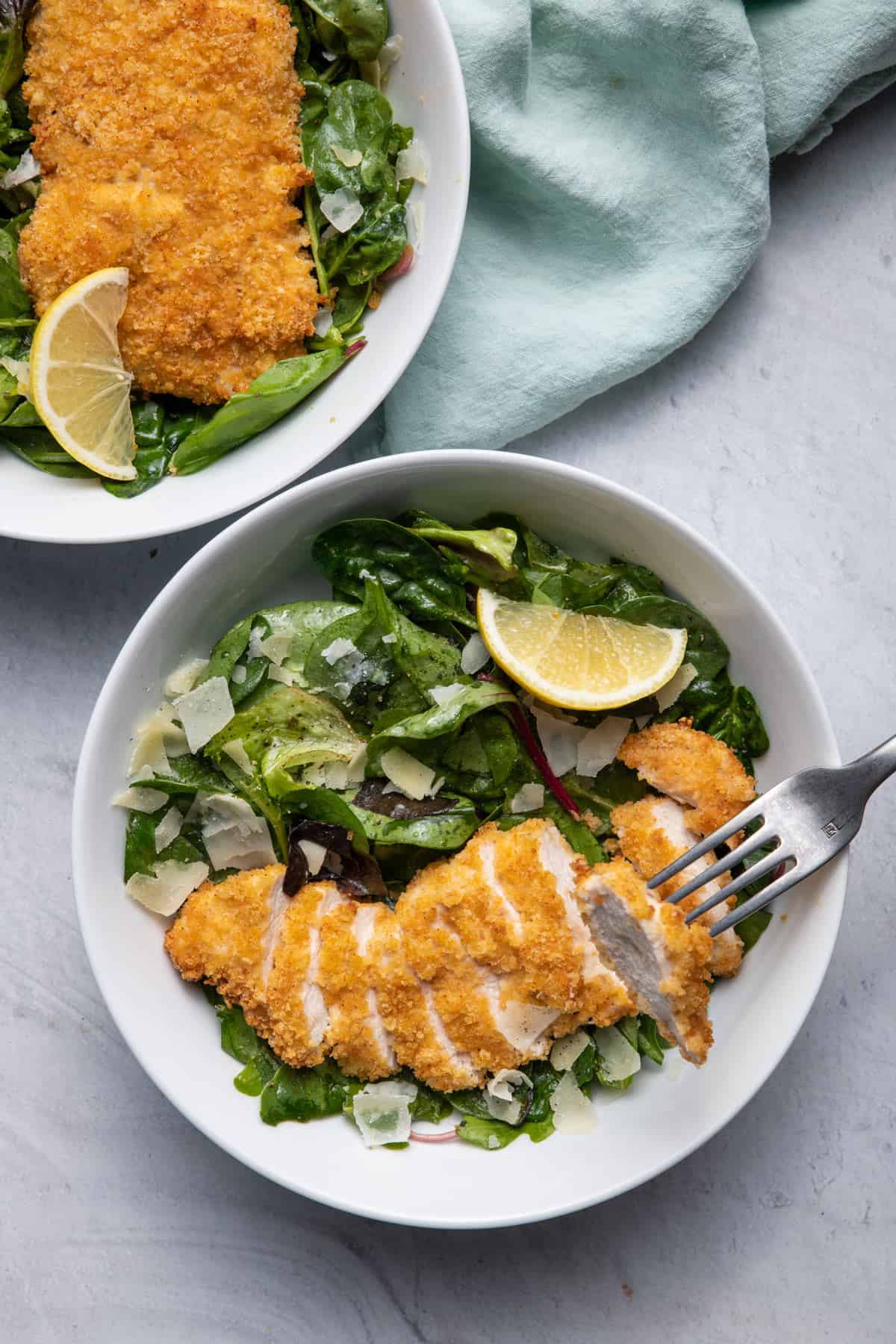 Fried Chicken Parmesan Salad in two bowls with fork grabbing a bite