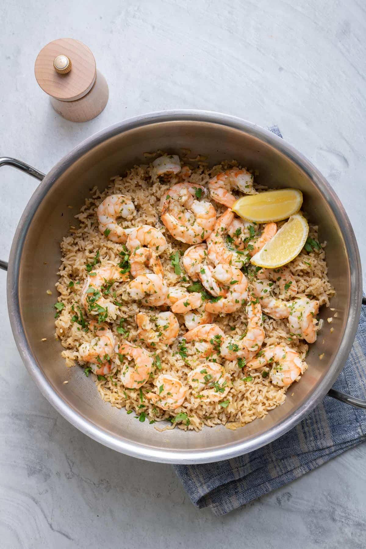 Finished shrimp and rice recipe garnished with lemon wedges in the pot