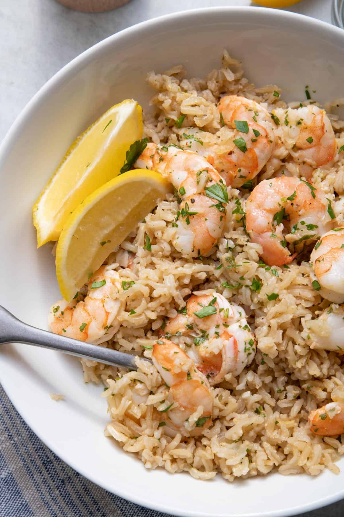 Close up shot of the lemon herb shrimp and rice with spoon inside bowl