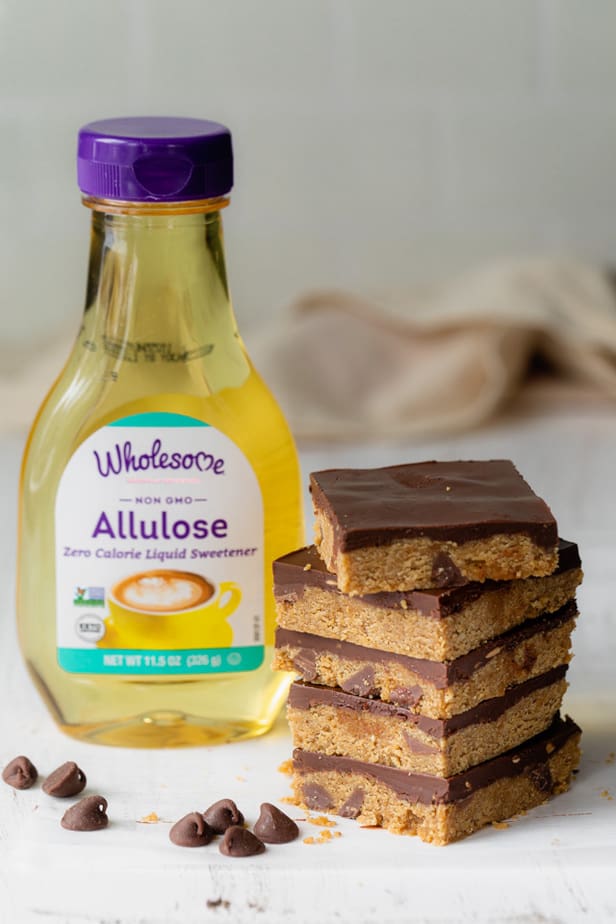 Stack of cookie dough bars with bottle of sugar free Wholesome Allulose next to them - used to make them