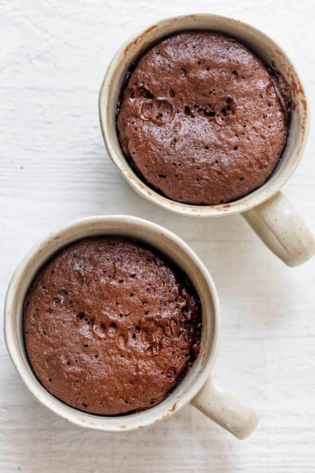 Two mugs with the chocolate mug cake after microwaving