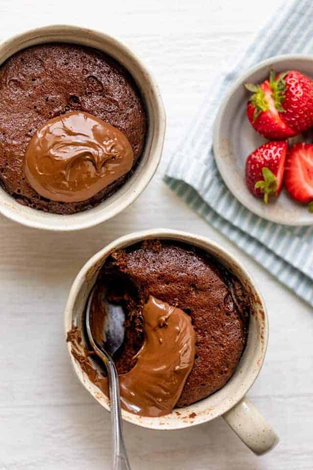 Nutella mug cake divided into two mugs made in one mug in one minute for one person, this Crumbly Nutella Mugcake is the perfect quick treat for a sweet tooth!