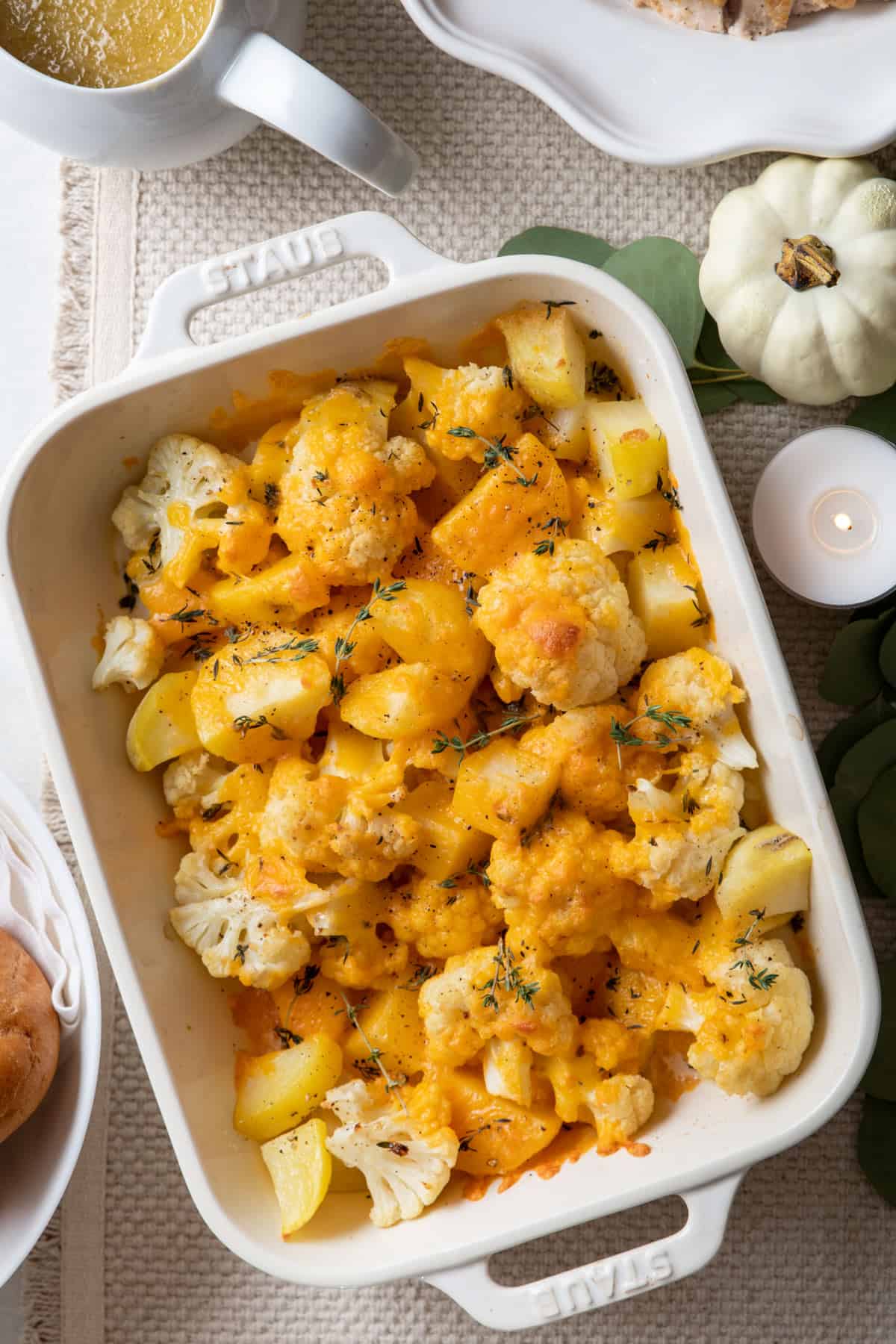 Potato cauliflower casserole after baking set on Thanksgiving dinner with sides around
