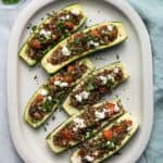 Top down shot of Quinoa Stuffed Zucchini boats on a large white plate