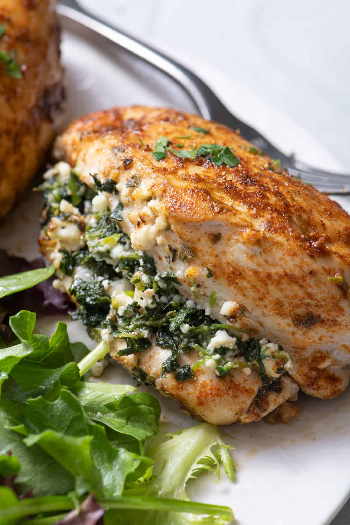 Close up shot of spinach and feta stuff chicken on plate