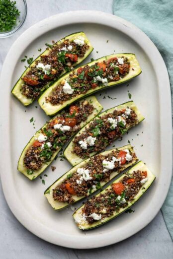 Top down shot of Quinoa Stuffed Zucchini boats on a large white plate