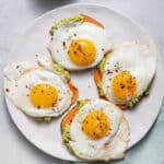 Overhead shot of sweet potato slices with mashed avocado and egg on top