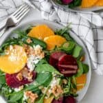 Beet orange salad topped with feta cheese and walnuts