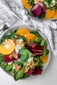 Beet orange salad topped with feta cheese and walnuts