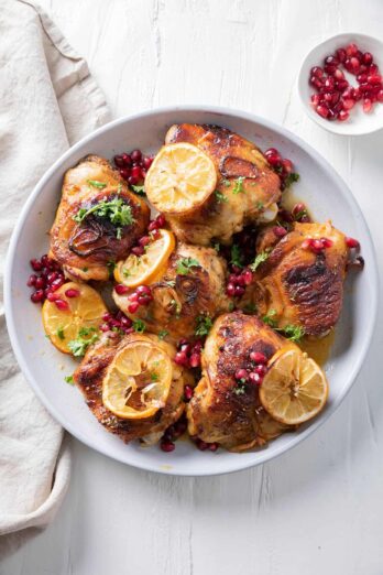 Pomegranate roasted chicken with lemon slices and pomegranate on the side