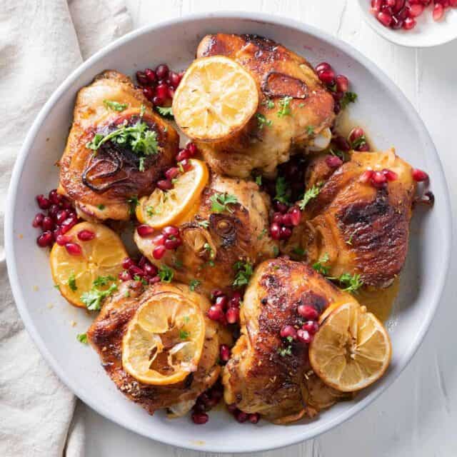 Pomegranate roasted chicken with lemon slices and pomegranate on the side