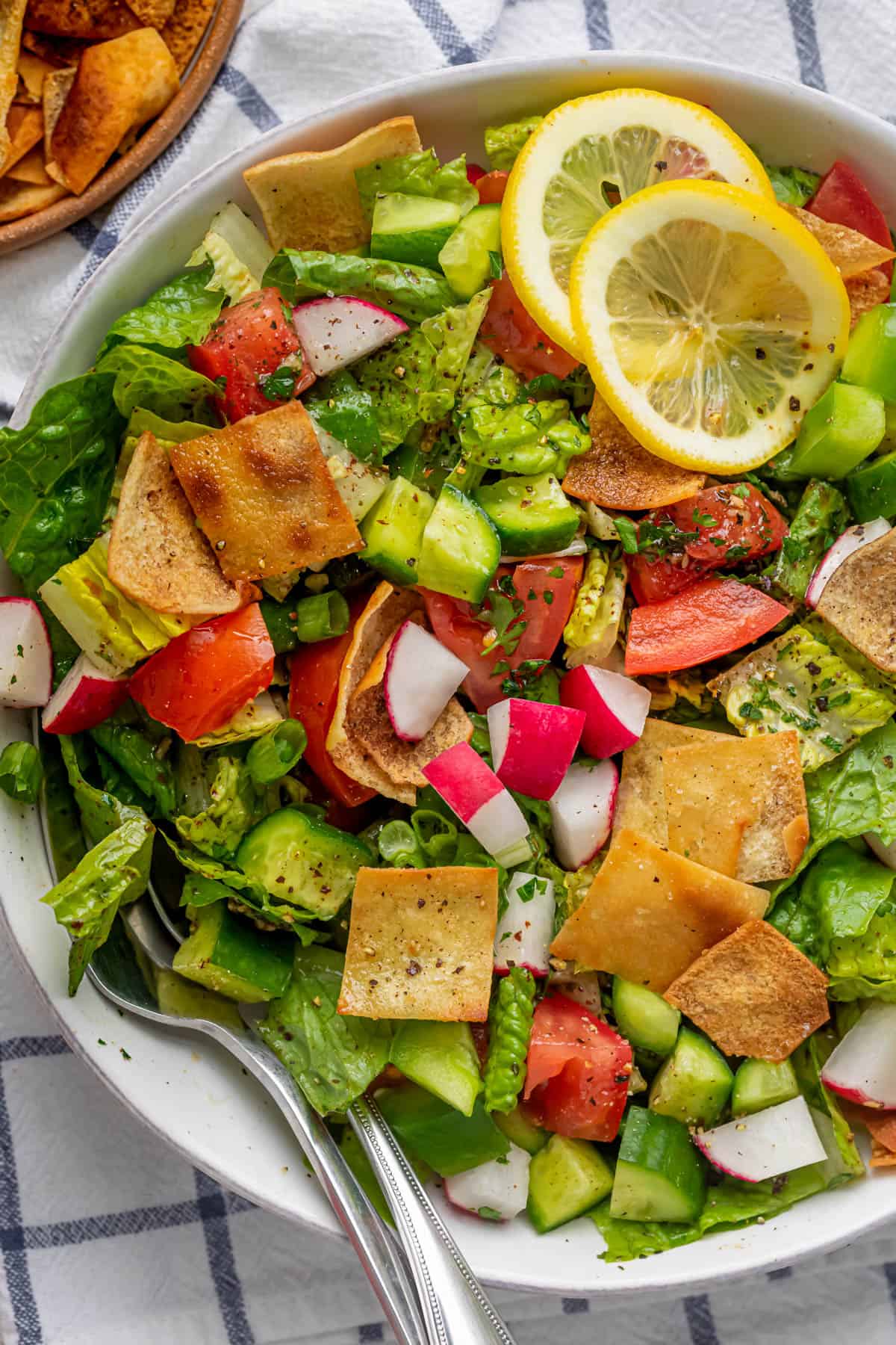 Close up shot of the final fattoush salad with fork and spoon in the bowl for serving