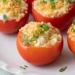 Stuffed tomatoes with fresh basil on plate with focus on one.