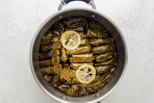 Pot of grape leaves with lemon on top after cooking