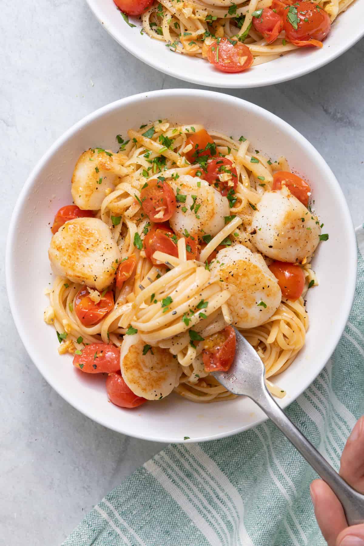 Close up shot of one bowl of pan seared scallops with pasta