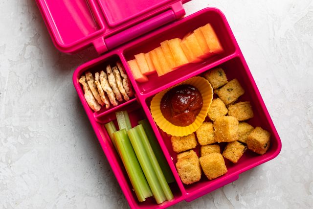 Sweet potato tater tots with ketchup, celery sticks, cantaloupe and cheddar cheese mini rice cakes.