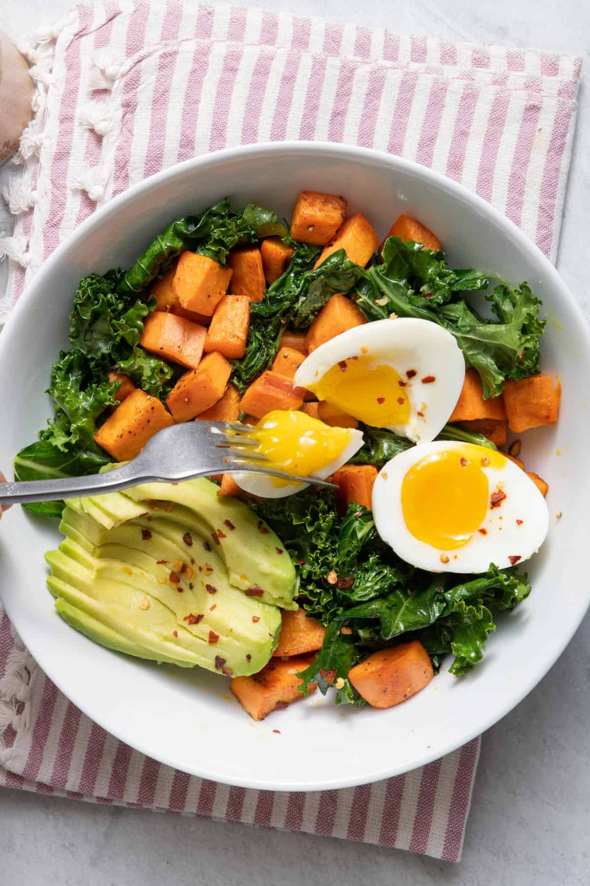 Top down shot of the egg and sweet potato breakfast bowl topped with avocado