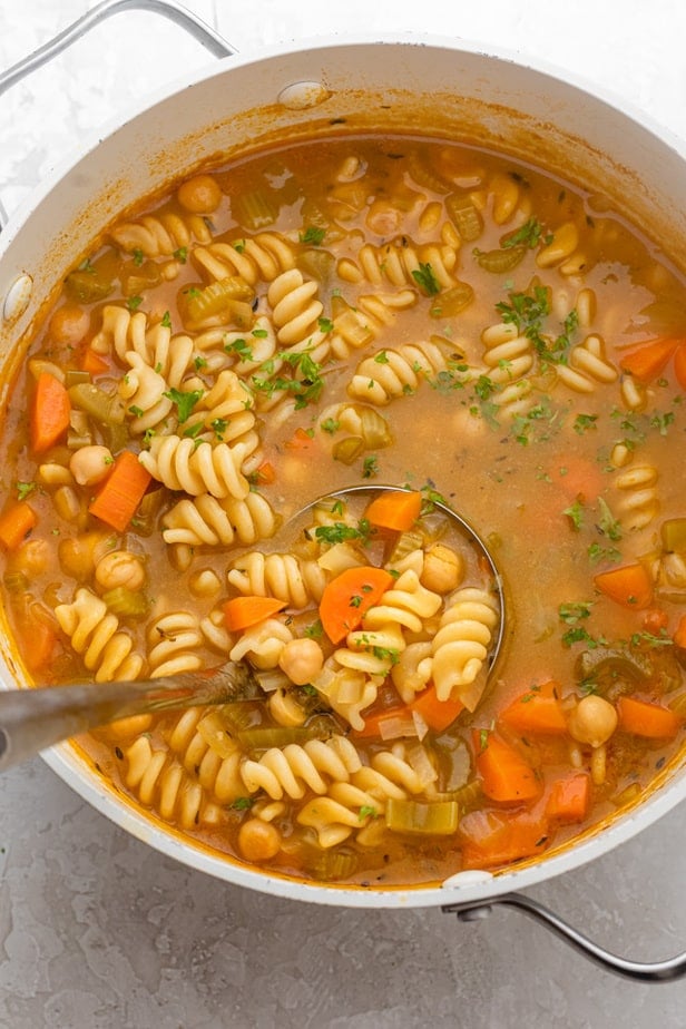 Large pot of chickpea soup with ladle inside