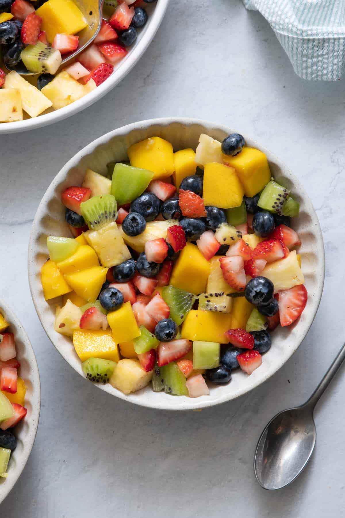 Overhead image of fruit salad with spoon on side of dish.
