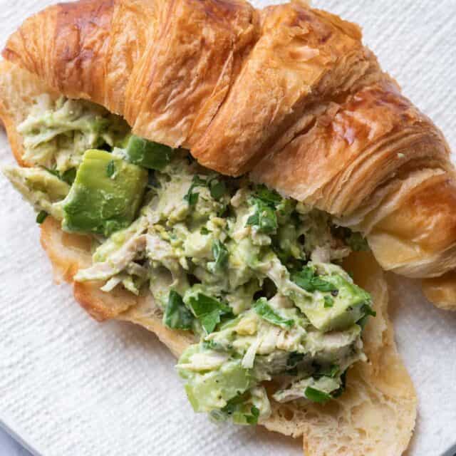 Avocado chicken salad served in a croissant for an easy lunch sandwiche