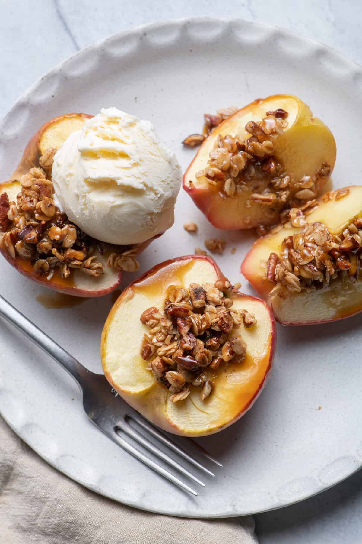 Cinnamon Baked Apples with Oats & Pecans in a blue bowl with ice cream