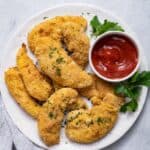 Oven Fried Chicken Tenders on a white plate served with ketchup