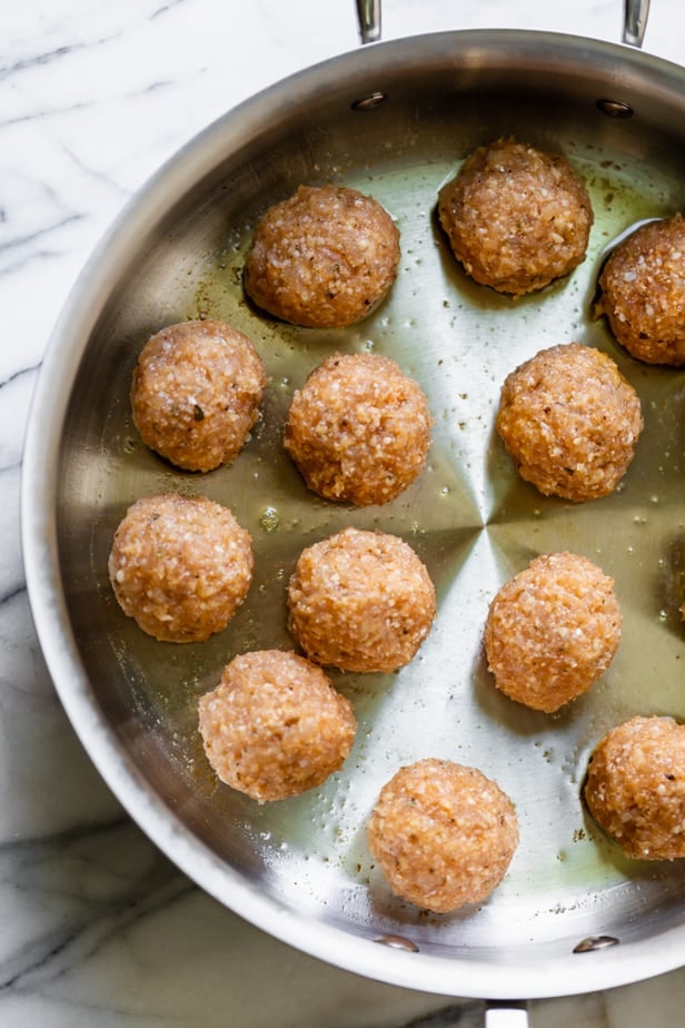 Chicken meatballs in a pan with olive oil before cooking