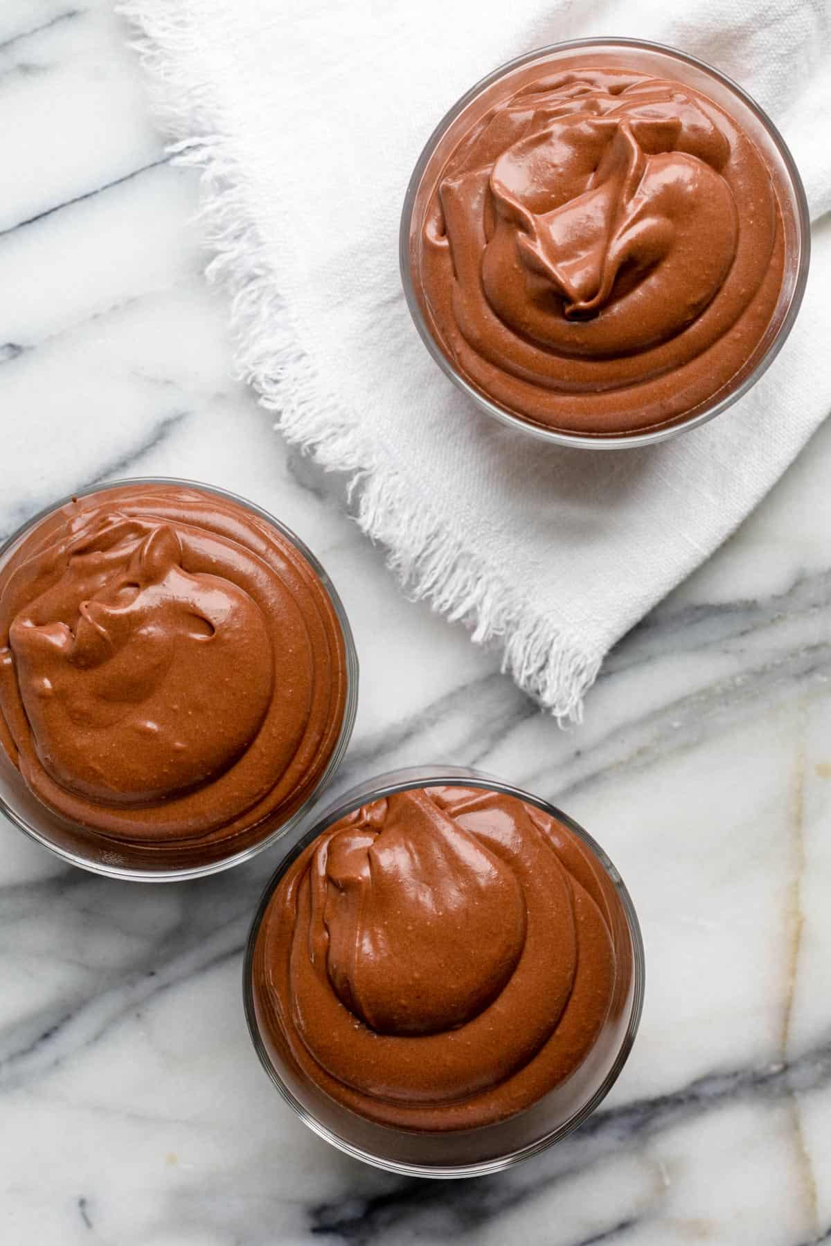 Top view of three cups of chocolate mousse