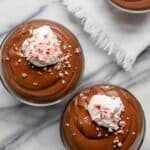Three small bowls of chocolate peppermint mousse topped with cream and peppermint
