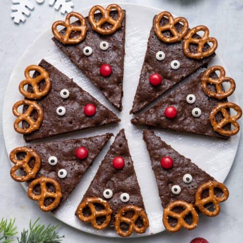 Large white platter of reindeer brownies cut up into triangles and decorated