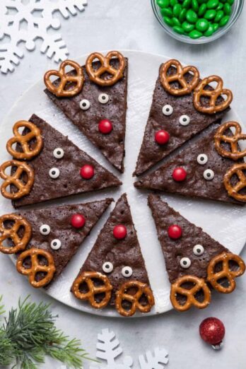 Large white platter of reindeer brownies cut up into triangles and decorated