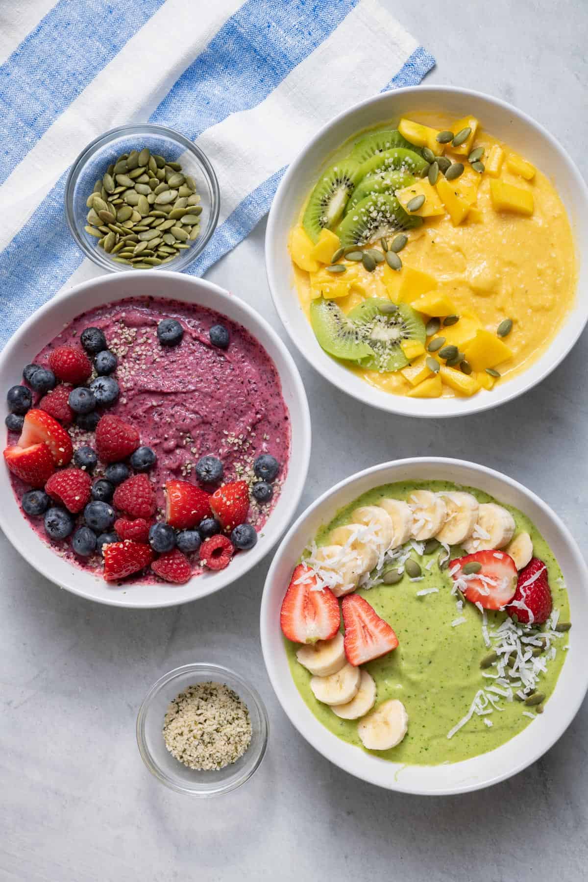 My FeelGood Smoothie Bowls are a refreshing and nutritious breakfast or snack idea. You can make them with with any frozen fruits of choice with a touch of milk, like coconut milk. There are three variations in this recipe, one with banana/mango, one with raspberries/strawberries, and one with blackberries/blueberries!