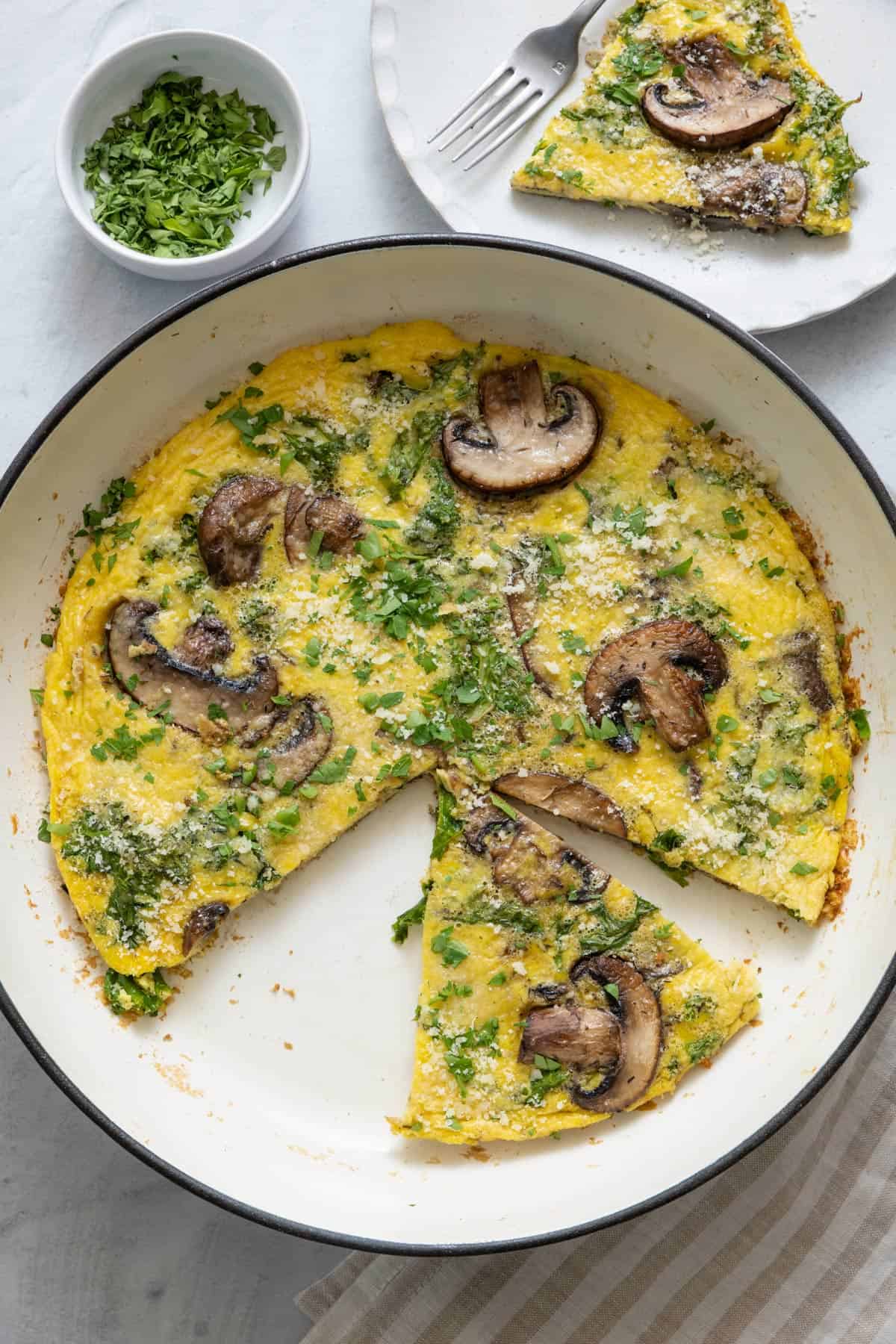 Mushroom frittata with a piece cut out and served on the side.